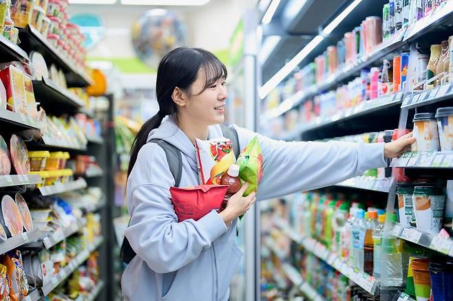 편의점에서 간편식과 음료 등을 고르는 소비자 모습. 근거리에서 소량을 자주 구매하는 소비 패턴이 확대되면서 편의점 이용이 증가하고 있다. 게티이미지뱅크