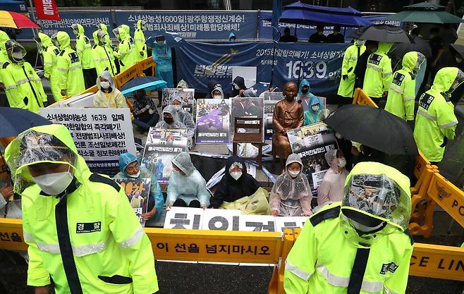 2020년 6월 24일 오전 서울 종로구 옛 일본대사관 앞 소녀상 주위에서 반아베반일청년학생공동행동 소속 학생들이 소녀상 철거를 요구하는 보수단체 회원들의 시위를 막기 위해 소녀상에 몸을 묶고 연좌시위를 벌이고 있다. 소녀상과 학생들을 보호하기 위해 설치된 바리케이드 주변에 경찰들이 서 있다. 박종식 기자 anaki@hani.co.kr