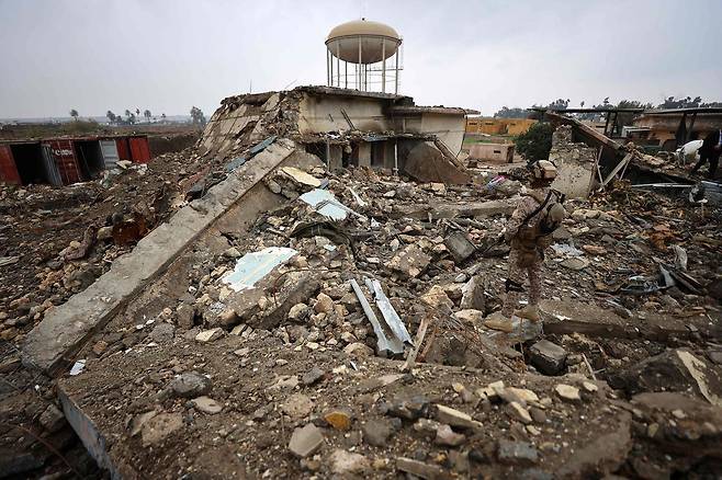 이라크군이 지난달 26일 바그다드 하바니야 군기지 내 공습으로 파괴된 보건소 현장을 살펴보고 있다. AFP=연합뉴스