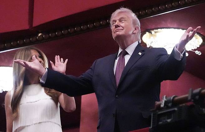 도널드 트럼프 미국 대통령이 지난 31일(현지시간) 스스로 '트럼프 센터'로 개명한 워싱턴의 케네디 센터에서 열린 뮤지컬 '시카고' 개막 공연에 멜라니아 여사와 함께 참석해 관객들에게 인사를 건네고 있다. 트럼프 대통령은 뮤지컬 관람 직전 이란에서 2~3주일 내에 철수할 뜻을 직접 밝혔다. AFP=연합뉴스