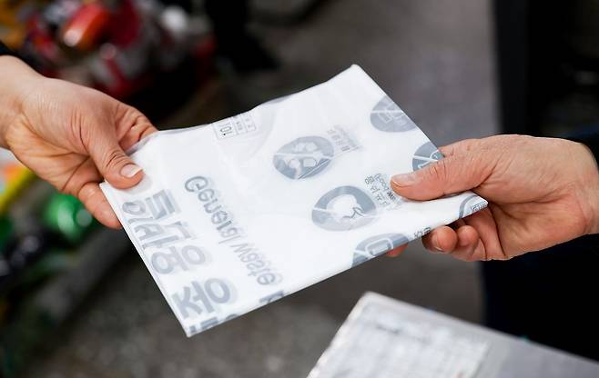 지난달 25일 서울 시내의 한 슈퍼에서 한 시민이 1인 1매 판매하는 종량제 봉투를 구입하고 있다. 우상조 기자