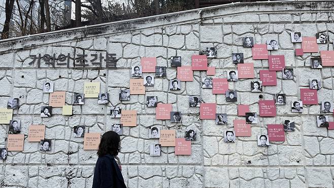 A person views murals on a wall. [WOO JI-WON]