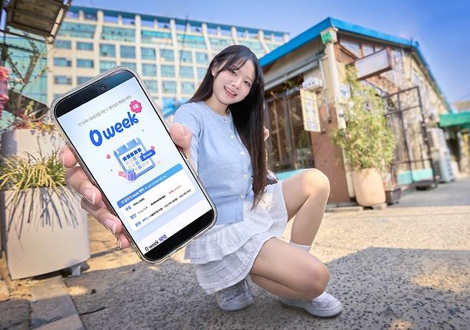 SK텔레콤 모델이 스마트폰 화면을 통해 새롭게 개편된 T멤버십 앱의 ‘0 week’를 소개하고 있다. <사진=SK텔레콤>