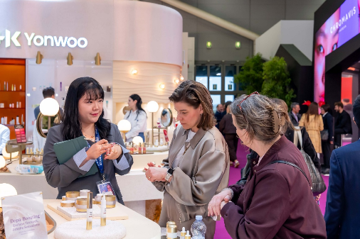 ‘코스모프로프 볼로냐 2026’에 참석한 바이어들이 한국콜마 부스에서 스킨케어 제품들을 직접 발라보는 등 체험하고 있다.  [한국콜마 제공]