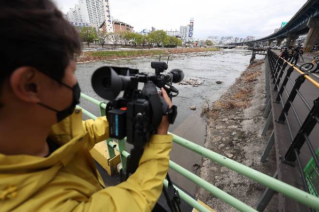 지난달 31일 대구 북구 칠성동 잠수교 아래 신천에서 여성의 시신이 담긴 캐리어가 발견된 가운데 캐리어가 발견된 지점에서 취재진이 취재하고 있다. 연합뉴스