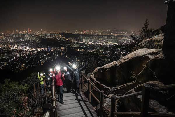 사당능선의 계단 뒤로 서울의 야경이 펼쳐진다.