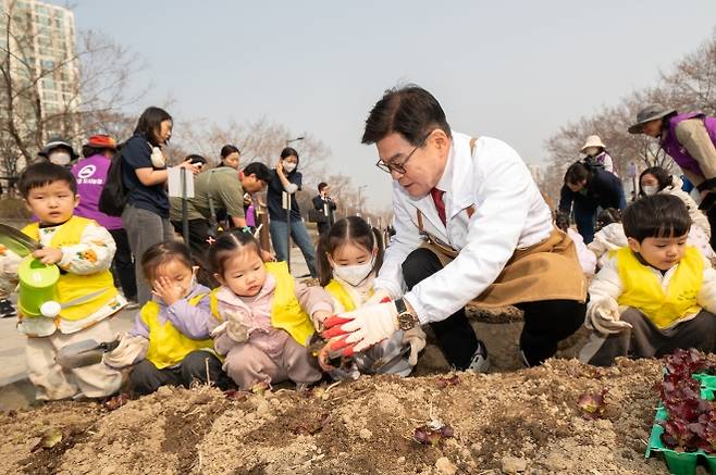 이필형 서울 동대문구청장이 지난달 27일 장안2수변공원 텃밭에서 어린이집 원아들과 상추를 심고 있다. 동대문구 제공