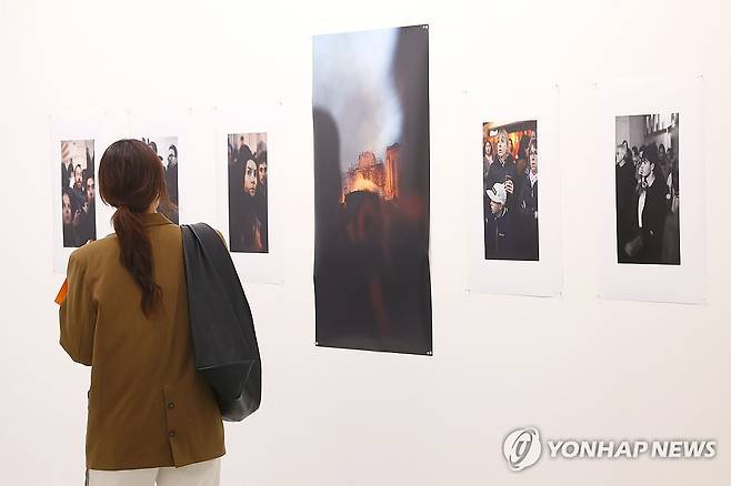 노트르담 대성당 화재 (서울=연합뉴스) 진연수 기자 = 2일 서울 종로구 성곡미술관에서 열린 사진전 '파리 보이지 않는 파리' 간담회에서 참석자가 그레구아르 엘루아의 '노트르담 대성당 화재' 작품을 살펴보고 있다. 
    이번 전시는 한국 작가와 프랑스를 대표하는 작가 등 총 51명이 참여해, 각자의 시선으로 파리 도시의 시간성과 일상의 풍경을 탐구한다. 2026.4.2 jin90@yna.co.kr