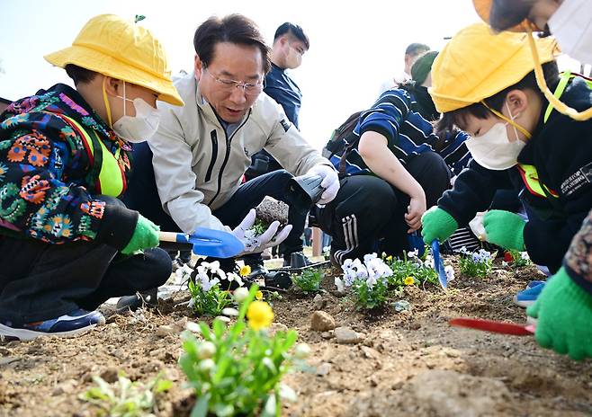 유정복 인천시장이 3일 문학공원에서 열린 식목일 행사에서 어린이들과 함께 꽃을 심고 있다.