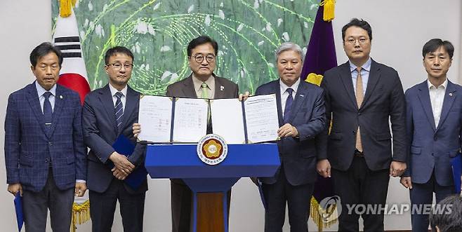 우원식 국회의장과 국회 내 정당 원내대표들이 31일 국회에서 열린 개헌 추진 관련 기자회견에서 각자 서명한 '대한민국 헌법 개정안 합의 서명부'와 '초당적 헌법개정 추진을 위한 국회 선언문'을 공개하고 있다.(사진=연합뉴스)