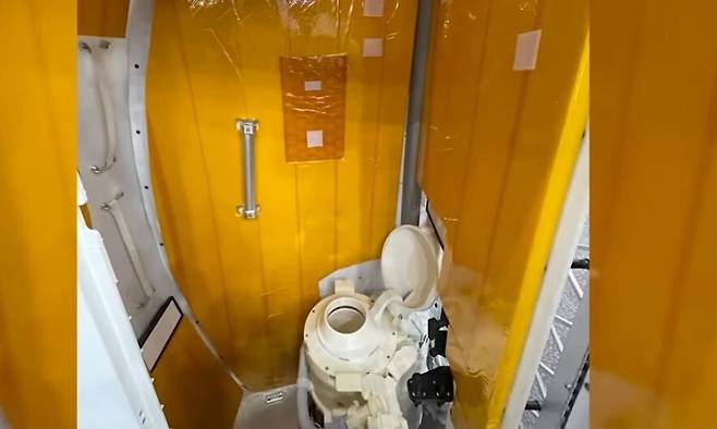아르테미스 2호 우주선의 출입구 근처 바닥에 고정된 화장실엔 문과 손잡이가 있다. 제레미 핸슨 유튜브 갈무리