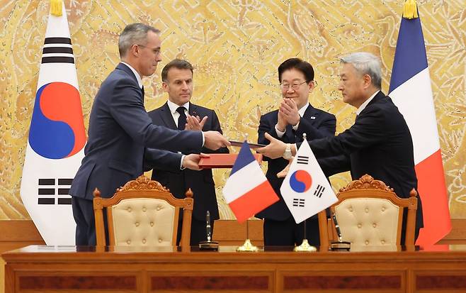 김회천 한국수력원자력 사장과 니콜라 마스 오라노 CEO가 3일 청와대에서 이재명 대통령과 에마뉘엘 마크롱 프랑스 대통령이 임석한 가운데 한수원-오라노 협력 양해각서 교환하고 있다. 전민규 기자