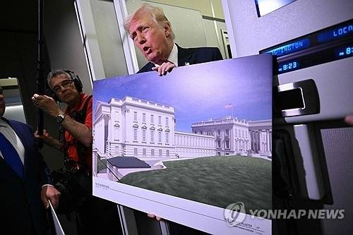 지난달 29일 미국 메릴랜드주 앤드루스 합동기지로 향하는 미국 대통령 전용기 에어포스원 기내에서 도널드 트럼프 미국 대통령이 백악관 연회장 설계안을 담은 대형 포스터를 기자들에게 보여주고 있다. AFP연합뉴스