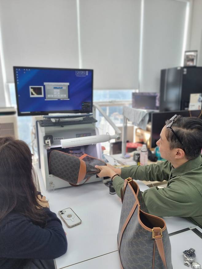 김재군 번개장터 검수센터 본부장이 헤럴드경제와 인터뷰에서 셀린느 가방 정·가품 판정을 위해 금속 부자재를 XRF 비파괴 성분 분석기에 넣고 있다. [번개장터 제공]