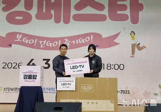 [의정부=뉴시스] 김도희 기자 = 3일 오후 의정부워킹페스타에서 진행된 경품 행사에서 박희성 의정부문화재단 대표(왼쪽)가 LED TV에 당첨된 참가자와 기념사진을 촬영하고 있다. 2026.04.03 kdh@newsis.com