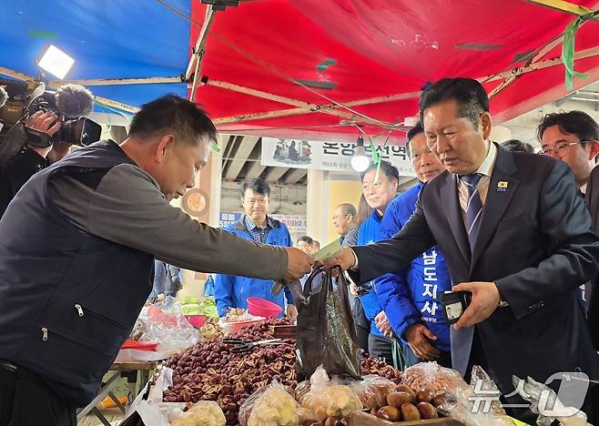 4일 충남 아산 온양온천역을 방문한 정청래 더불어민주당 대표가 물건을 구입하고 있다. ⓒ 뉴스1 2026.4.4. 이시우 기자