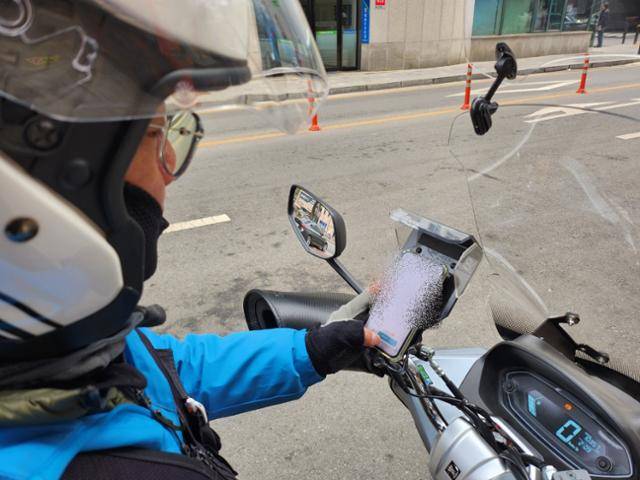 1일 경기 고양시 주엽역 인근에서 만난 배달노동자 심의석씨가 배달플랫폼 콜 배정 화면을 들여다보고 있다. 송주용 기자