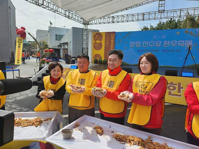 왼쪽부터 지민희 양평군의회 부의장, 남동현 축제위원장, 전진선 양평군수, 이혜원 경기도의회 의원이 초대형 육회비빔밥 만들기 퍼포먼스에 참여하고 있다. <안유신 기자>