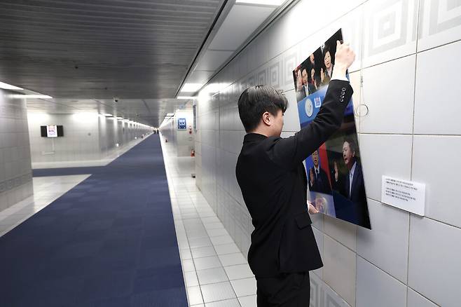 지난 3월3일 국회 본관과 의원회관을 잇는 지하통로에 있던 윤석열 전 대통령의 모습이 담긴 사진이 철거되고 있다. 연합뉴스