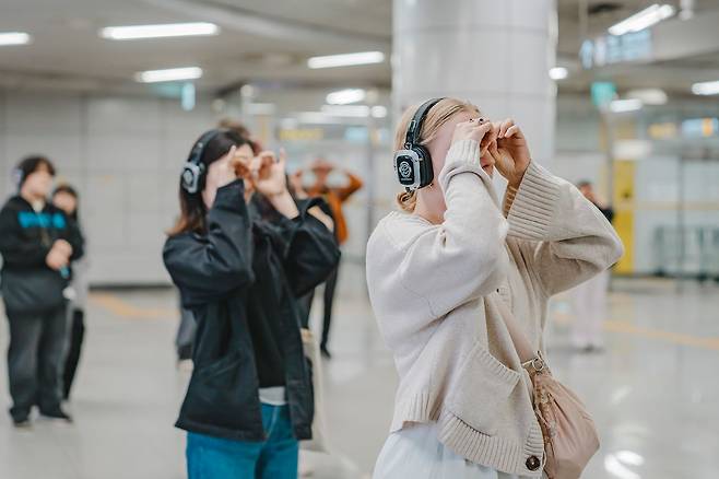 ‘리모트 서울’에서 관객들이 AI의 지시에 따라 손을 망원경처럼 만들었다. 사진 GS아트센터