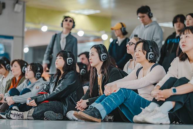 ‘리모트 서울’ 참가자들이 지하철역 개찰구 앞에 모여서 바삐 지나가는 사람들을 살펴보는 모습. 사진 GS아트센터