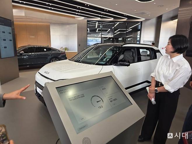 전시된 차량 앞에 기아가 점검한 인증서가 표시돼 있다. /사진=최유빈 기자