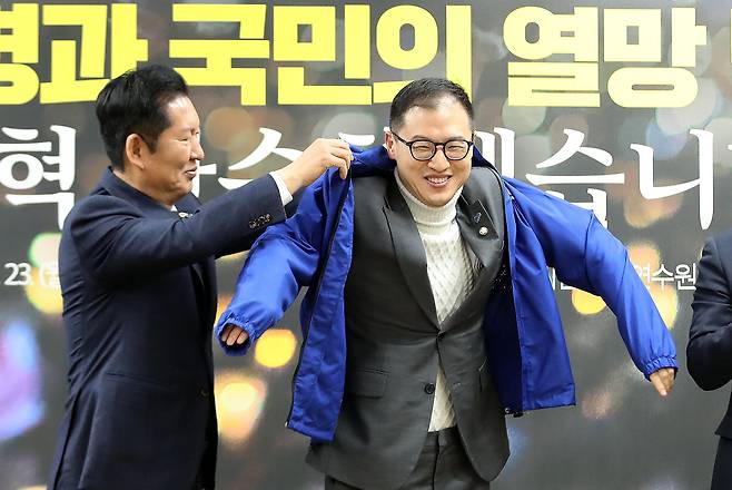 정청래 더불어민주당 대표가 23일 오전 경남 김해 진영읍 강금원 기념 봉하연수원에서 열린 봉하마을 현장 최고위원회의에서 김상욱 울산시장 후보에게 당 점퍼를 입혀주고 있다. /뉴스1