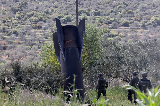 지난달 24일(현지 시각) 이스라엘군이 이란이 발사한 것으로 추정되는 탄도미사일 잔해를 점검하고 있다. / EPA=연합