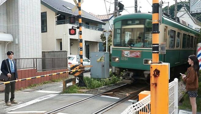 배우 김선호(왼쪽), 고윤정 주연의 넷플릭스 드라마 '이 사랑 통역 되나요?'에 등장한 일본 가나가와현 가마쿠라 주택가 옆 철도 건널목. 극 중 남녀 주인공의 첫 만남 장소로 등장해 드라마 팬들 사이에서 명소로 떠올랐다. 사진 넷플릭스 인스타그램