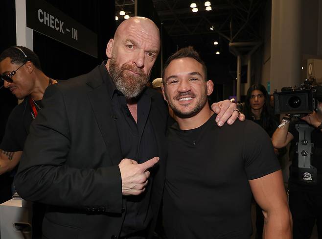 유명 프로레슬러 ‘트리플H’ 마이클 폴 르베스크(왼쪽)와 기념촬영하는 마이클 챈들러 [게티이미지]