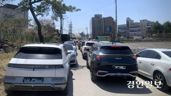 7일 오전 수원시 권선구 오목천동 황구지천 진입로. 평일 오전임에도 양쪽으로 불법 주차된 차량들 사이로 진입 차량이 줄지어 늘어서 있다. 2026.4.7 /유혜연기자 pi@kyeongin.com