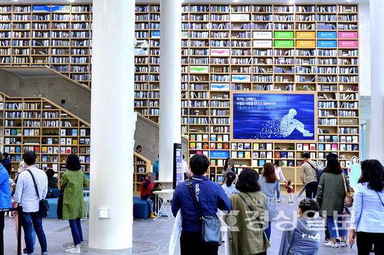 ▲ 울산도서관을 찾은 시민들이 거대한 책장이 벽면을 채우고 있는 로비를 지나고 있다. 경상일보 자료사진