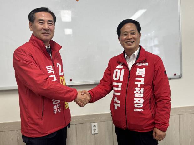6·3 지방선거 대구 북구청장에 뛰어든 국민의힘 소속 이근수(오른쪽) 및 이동욱 예비후보가 지난 6일 '단일후보'를 내기로 합의한 뒤 악수를 나누며, 결과에 깨끗이 승복할 것을 다짐하고 있다. 이근수 예비후보 제공