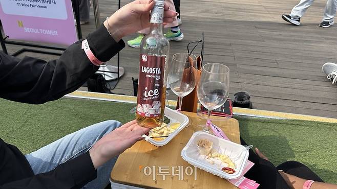 4일 서울 용산구 N 서울타워에서 진행된 '2026 남산 와인페어'에서 외국인 방문객들이 구입한 와인을 소개하고 있다.(사진=연희진 기자)