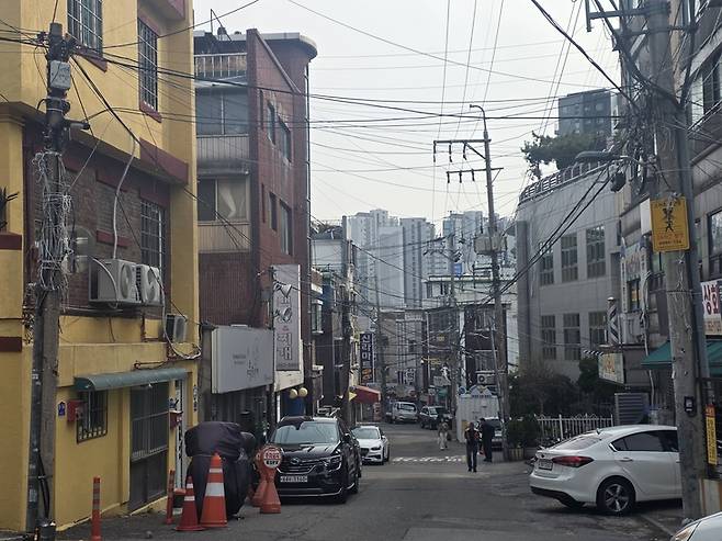 ▲북아현뉴타운 내 노후 주거지 뒤로 신축 아파트 단지가 보이고 있다. 같은 생활권에서도 개발 속도에 따라 주거 환경이 극명하게 갈리는 모습이다. 사진=장혜원 기자