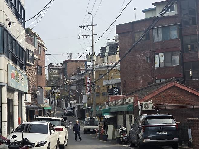 ▲서울 서대문구 북아현동 일대 주택가 골목 모습. 노후 저층 주거지와 복잡한 전선, 협소한 도로 환경이 혼재된 가운데 재개발 지연 속에서도 주거 환경은 크게 개선되지 않은 모습이다.