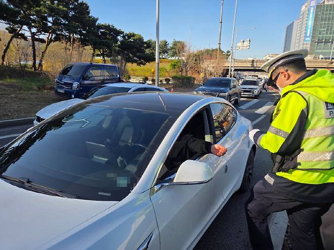 서초경찰서 소속 교통경찰관이 7일 오전 서울 서초구 양재IC서울방향으로 진입하던 중 끼어들기를 시도해 적발된 운전자에게 범칙금을 부과하고 있다.(사진=김현재 기자)
