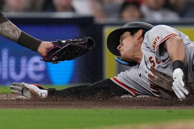 San Francisco Giants' Jung Hoo, right, is tagged out by San Diego Padres third baseman Manny Machado trying to advance to third off a double during the fifth inning of a baseball game Tuesday, March 31, 2026, in San Diego. AP연합뉴스