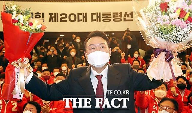 윤석열 대통령이 지난 2022년 3월 10일 새벽 서울 여의도 국회도서관에 마련된 '국민의힘 제 20대 대통령선거 개표상황실'을 찾아 꽃다발을 받고 있다. / 더팩트DB