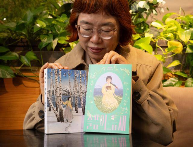 이금이 작가가 지난해 펴낸 '여성 디아스포라 3부작'의 마지막 권인 '슬픔의 틈새'와 최근 출간된 청소년판(오른쪽)을 보여주고 있다. 그는 "내가 쓰고 싶은 게 동화이고, 내 작품의 독자가 어린이였으면 좋겠다는 걸 뒤늦게 알았다"며 "내가 아동문학을 선택한 게 아니라 아동문학이 나를 선택한 것"이라고 했다. 최주연 기자