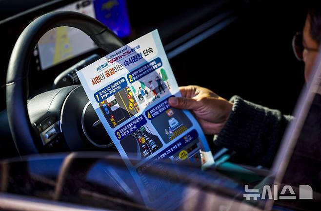 [서울=뉴시스] 정병혁 기자 = 7일 서울 서대문구 연세대학교 앞 성산로에서 운전자가 꼬리물기 및 끼어들기 단속 관련 안내문을 보고 있다. 2026.04.07. jhope@newsis.com