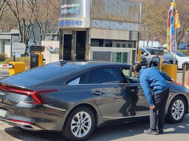 ▲ 8일 오전 10시30분쯤 인천 남동구 주차장 입구에서 청원경찰이 끝자리 8로 끝나는 차량을 타고 온 민원인에게 승용차 5부제에 대해 설명하고 있다.