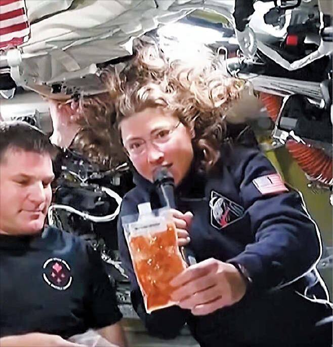 새우 칵테일 먹는 법 - 미국 항공우주국(NASA)이 공개한 ‘우주 먹방’ 영상에서 아르테미스 2호 우주비행사 크리스티나 코크(오른쪽)가 ‘새우 칵테일’ 봉지를 소개하고 있다. /NASA