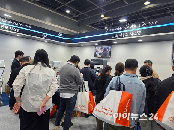 '2026 푸드페스타' 방문객들이 조리 자동화 시스템을 살펴보고 있다. [사진=구서윤 기자]