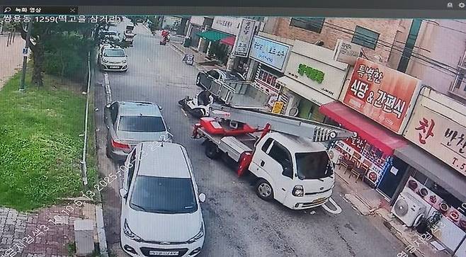 [천안=뉴시스] 지난 해 8월23일 오전 11시21분께 충남 천안시 쌍용동 떡고을 삼거리 일원에서 30대 오토바이 배달원이 후진하기 위해 속도 줄이는 화물차 뒤에 바짝 붙어 들이받게 한 뒤 오토바이와 함께 쓰러지고 있다. (사진=충남경찰청 제공) 2026.04.08. photo@newsis.com *재판매 및 DB 금지