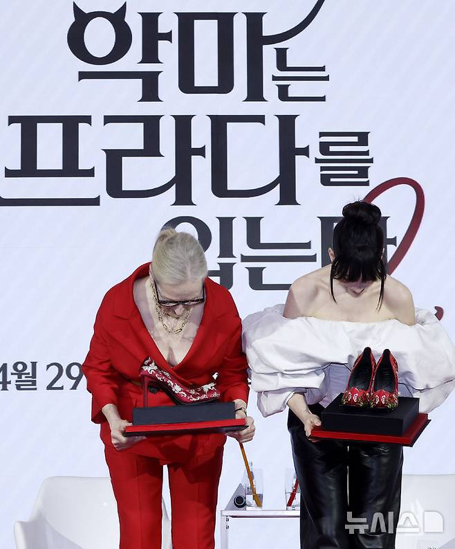 [서울=뉴시스] 김혜진 기자 = 배우 메릴 스트리프(왼쪽), 앤 해서웨이가 8일 서울 종로구 포시즌스 호텔에서 열린 영화 '악마는 프라다를 입는다2' 내한 기자간담회에서 관계자에게 꽃신 선물을 받고 고개 숙여 인사하고 있다. 2026.04.08. jini@newsis.com