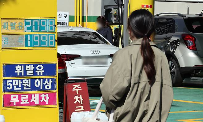 중동 전쟁 여파로 기름값 상승세가 지속된 7일 부산의 한 주유소에서 유류 가격 표시판 뒤로 승용차에 대한 주유가 진행되고 있다. 뉴시스