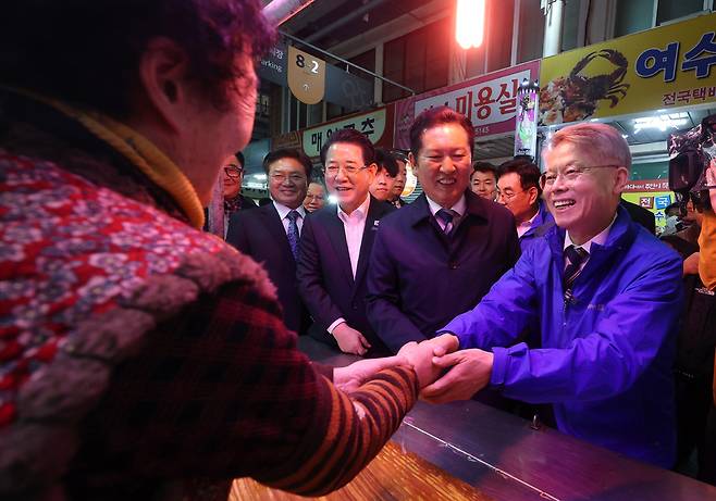 더불어민주당 정청래 대표와 민형배, 김영록 전남광주통합특별시장 후보가 9일 전남 여수시 서시장을 방문해 시장 상인들과 인사하고 있다./ 연합뉴스