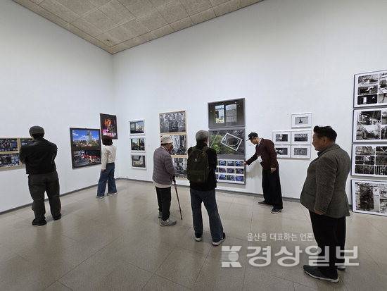 ▲ 8일 울산 100인 사진제 '울산 사진, 기록과 예술 사이'를 찾은 관람객들이 조원채 큐레이터의 설명과 함께 작품을 감상하고 있다.