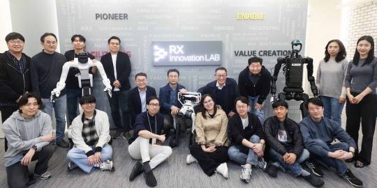 Employees pose for a commemorative photo at the launch ceremony of the LG CNS RX Innovation Lab. Pictured in the back row: Hyun Shin-kyun, CEO of LG CNS (4th from right); Lee Jun-ho, EVP and Head of Smart Logistics & City Division (5th from left); Park Sang-yeop, CTO and Senior Vice President (3rd from right); Myeong Chang-guk, Senior Vice President in charge of Smart Logistics Center/Robotics (4th from left)./ Photo = LG CNS